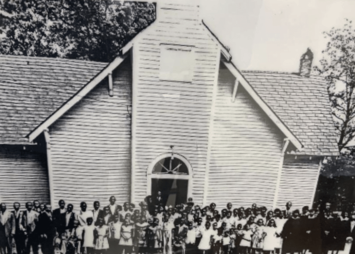 Historic photo of the early congregation of Bethlehem United Methodist Church standing outside the original wooden sanctuary, dating back to the church’s early formation in Greenville, SC.